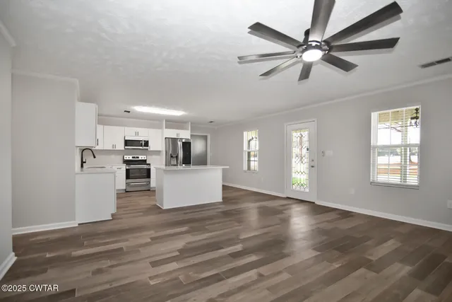 a view of a kitchen with furniture wooden floor and windows