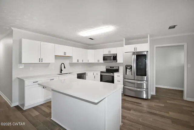 a kitchen with white cabinets and stainless steel appliances