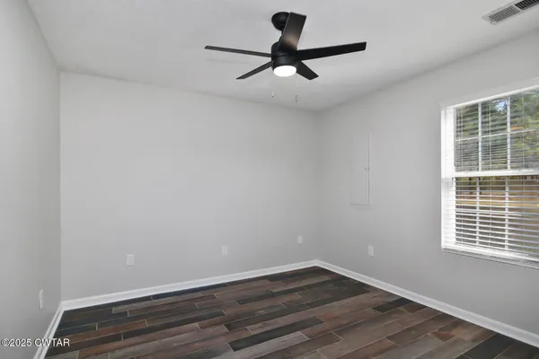a view of a room with wooden floor and a window