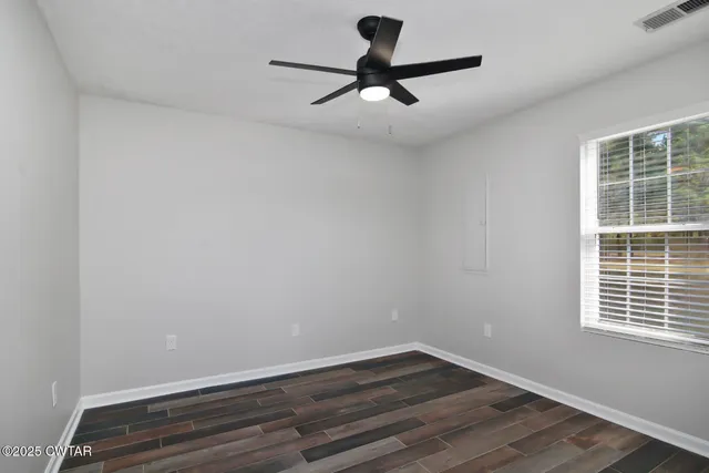 a view of a room with wooden floor and a window