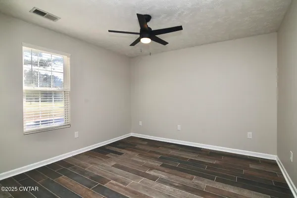 a view of a room with wooden floor and a window