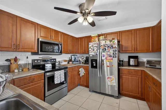 a kitchen with stainless steel appliances granite countertop a sink stove microwave and refrigerator
