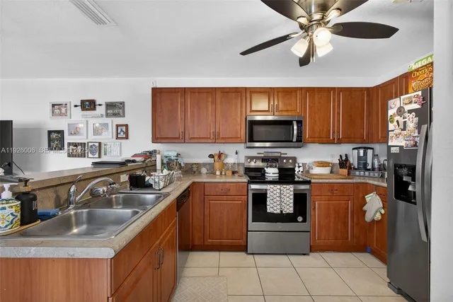 a kitchen with stainless steel appliances granite countertop a stove top oven a sink dishwasher and a microwave oven on the blue kitchen countertops
