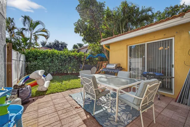 a view of a patio with a dining table and chairs