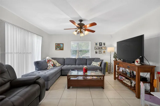 a living room with furniture a flat screen tv and a window