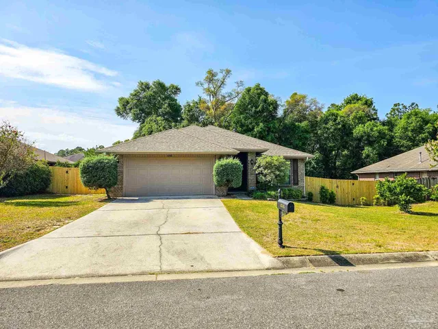 a front view of house with yard and trees in the background