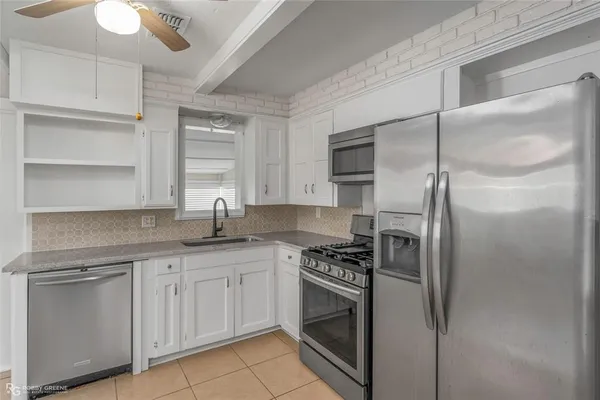 a kitchen with stainless steel appliances a refrigerator sink and stove