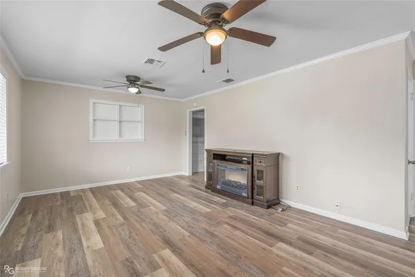 an empty room with a window and a fan