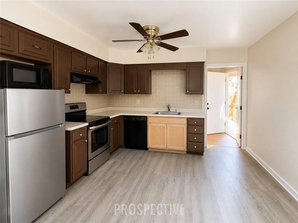 215 Maple Street Kittanning, PA 16201 - Photo 8 of 39 a kitchen with stainless steel appliances a refrigerator a sink a stove a microwave and wooden floors