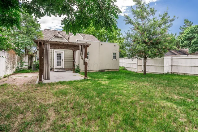 a view of a house with a yard and tree