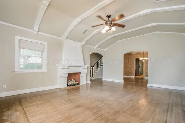 a view of an empty room with a fireplace and a window