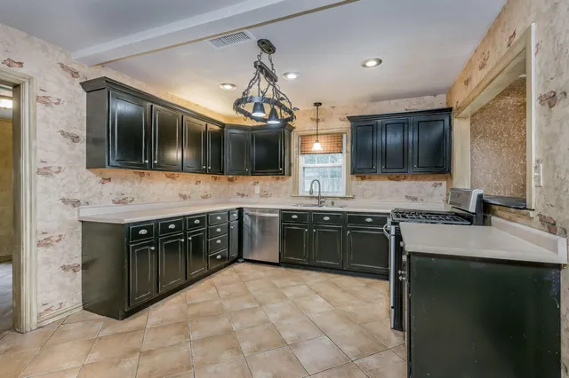 a large kitchen with cabinets stove top oven and sink