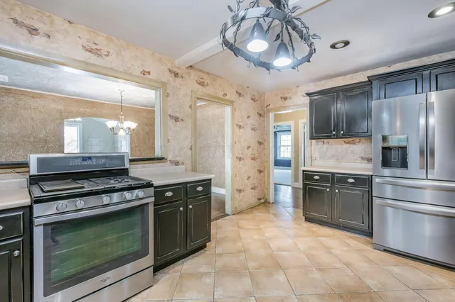 a kitchen with a stove top oven and refrigerator