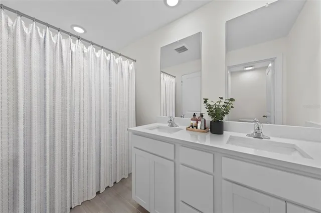 a bathroom with a double vanity sink and a mirror