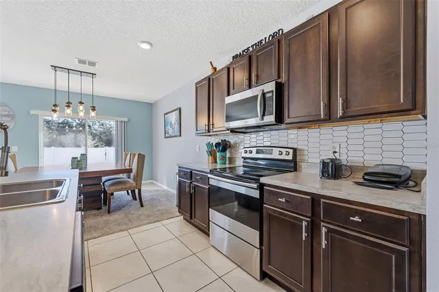 a kitchen with stainless steel appliances granite countertop a refrigerator and a stove top oven