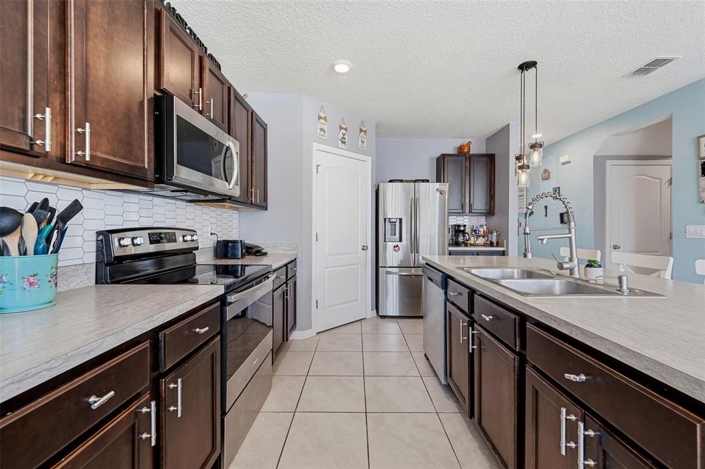 1526 White Hawk Way Groveland, FL 34736 - Photo 16 of 40 a kitchen with stainless steel appliances granite countertop a sink a stove and a refrigerator