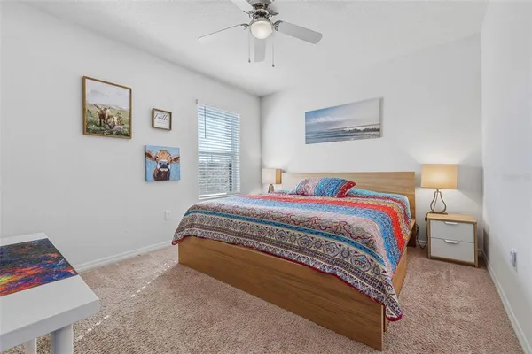 a spacious bedroom with a bed and a chandelier