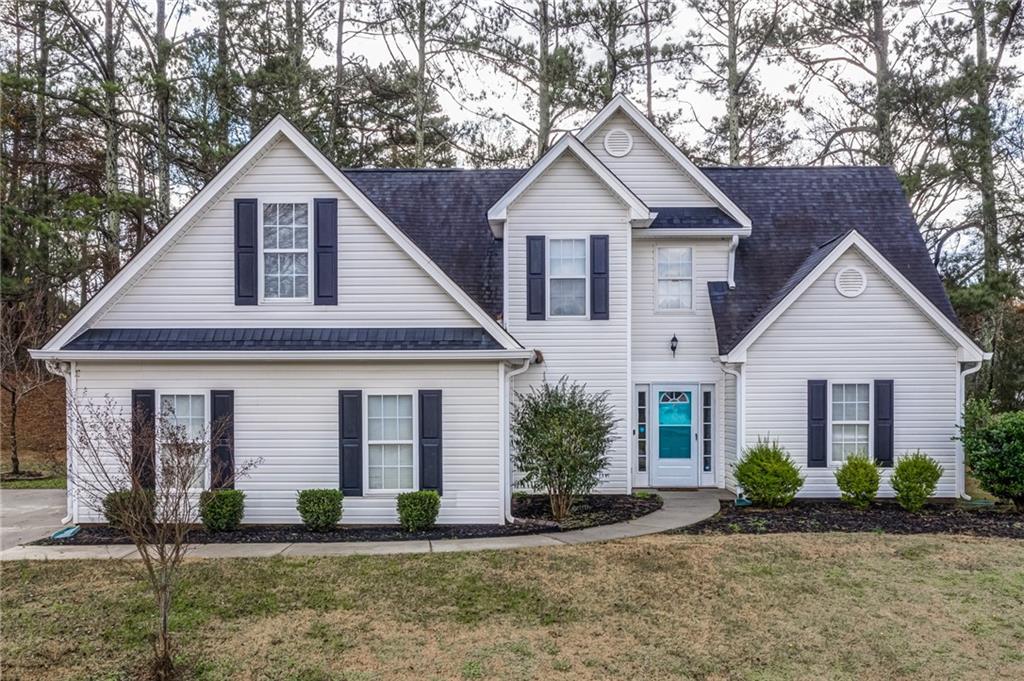 a front view of a house with a yard and potted plants