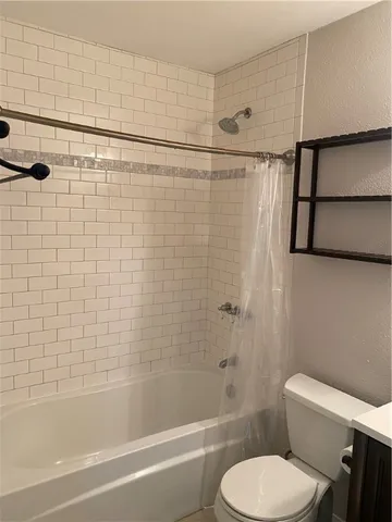 a bathroom with a toilet and a shower