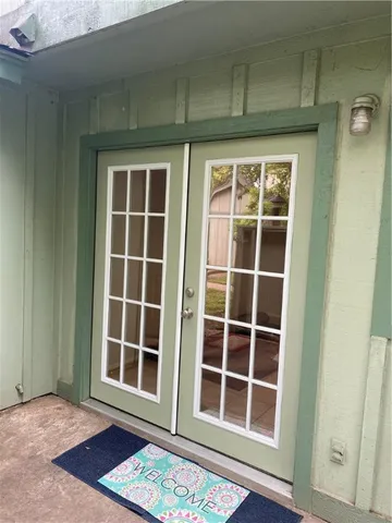 a view of front door with wooden floor and windows