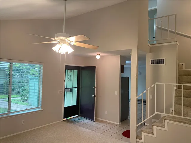 a view of a livingroom with a ceiling fan and window