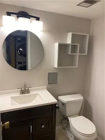 a bathroom with a sink vanity and toilet