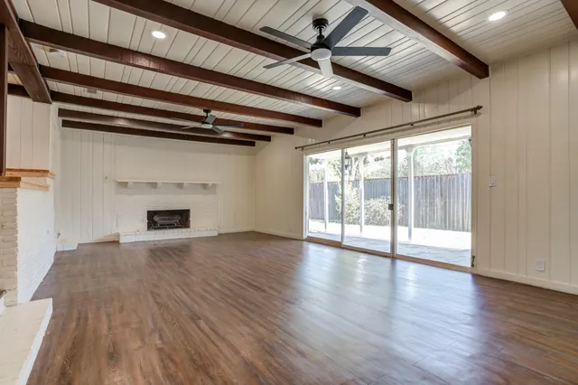 a view of empty room with wooden floor and fireplace