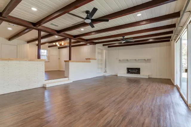 a view of empty room with wooden floor and fireplace