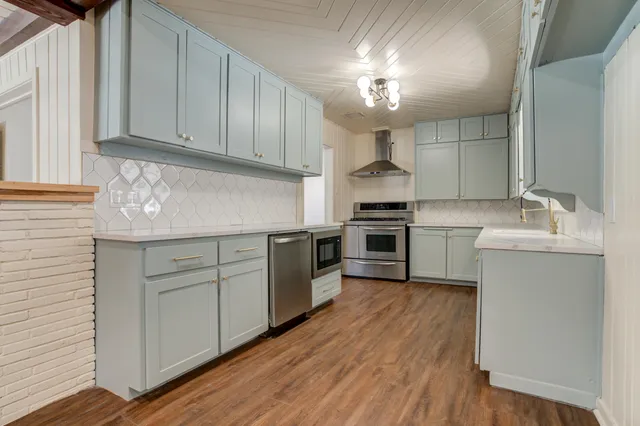a kitchen with cabinets a sink and stainless steel appliances