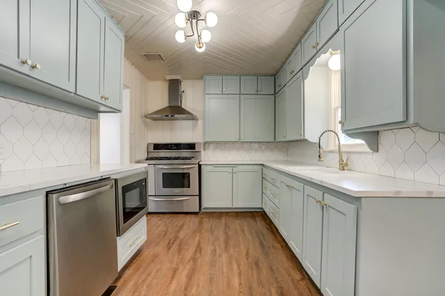 a kitchen with stainless steel appliances a sink stove and cabinets