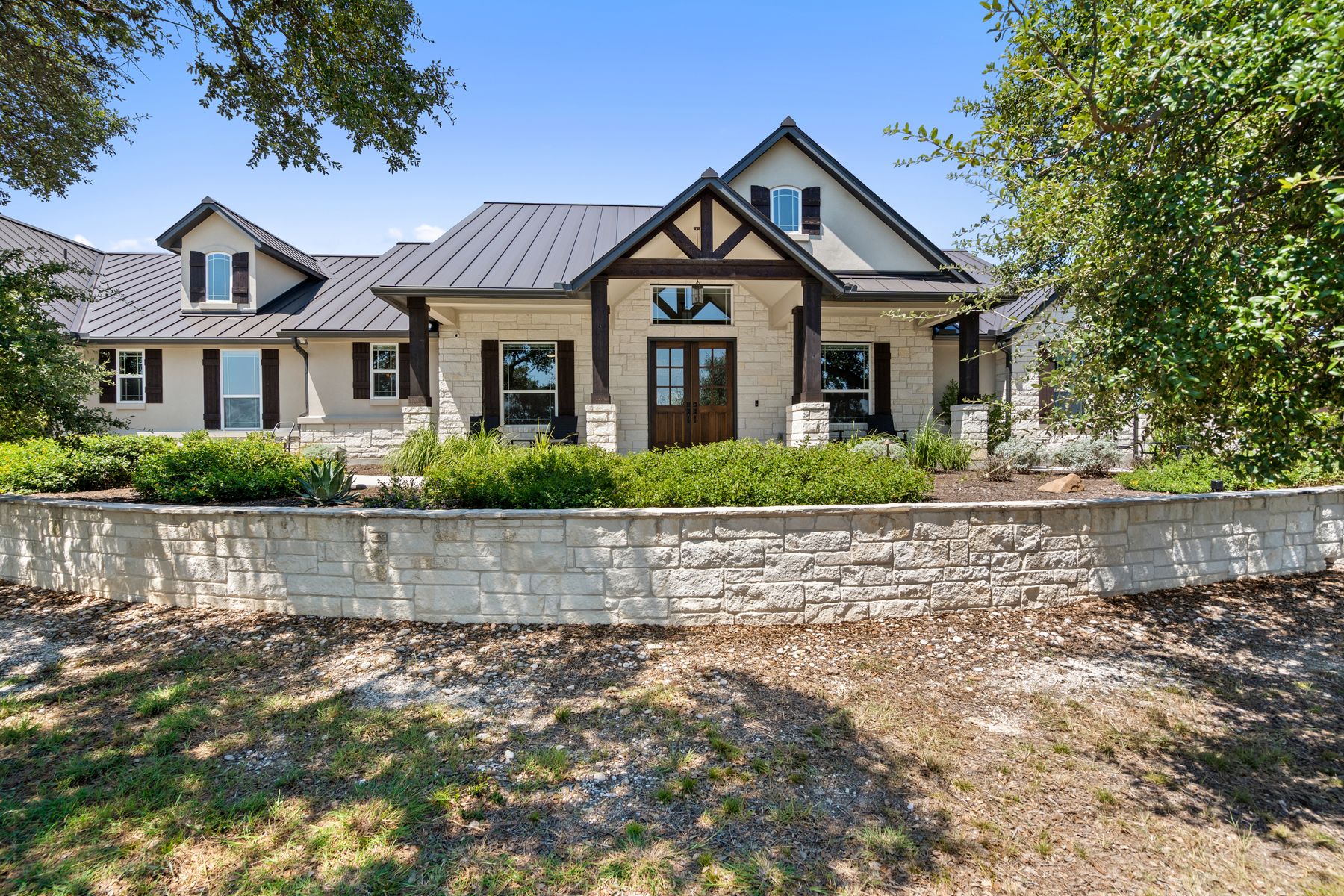 291 Southwick Ranch Road Johnson City, TX 78636 - Photo 1 of 1 View of front of property with a standing seam roof, a metal roof, stone siding, covered porch, and stucco siding