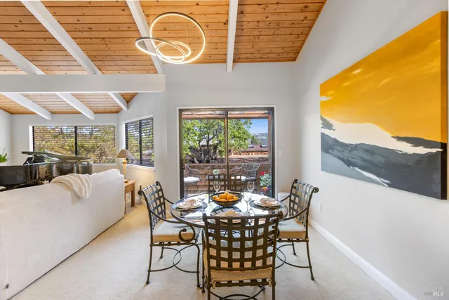 a dining room with furniture and a floor to ceiling window