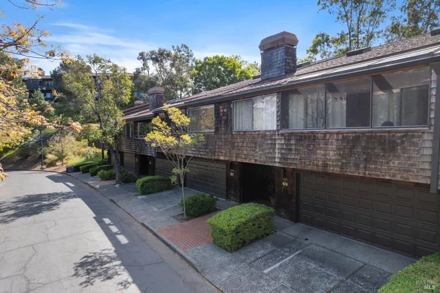 an aerial view of residential houses with outdoor space and trees