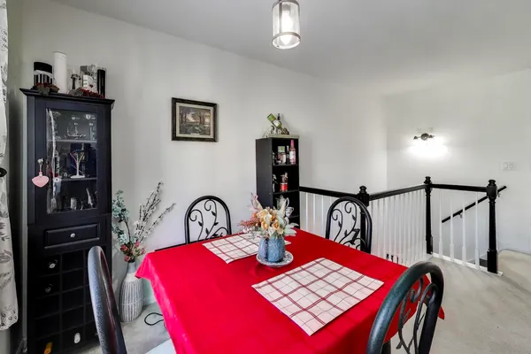 a kitchen with a sink dishwasher a stove a refrigerator and a dining table with wooden floor
