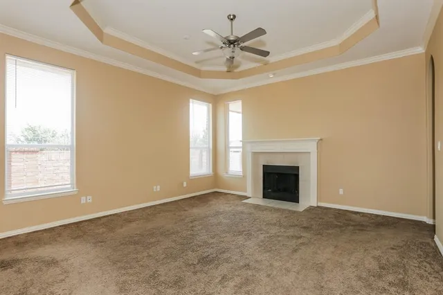 an empty room with windows and fireplace