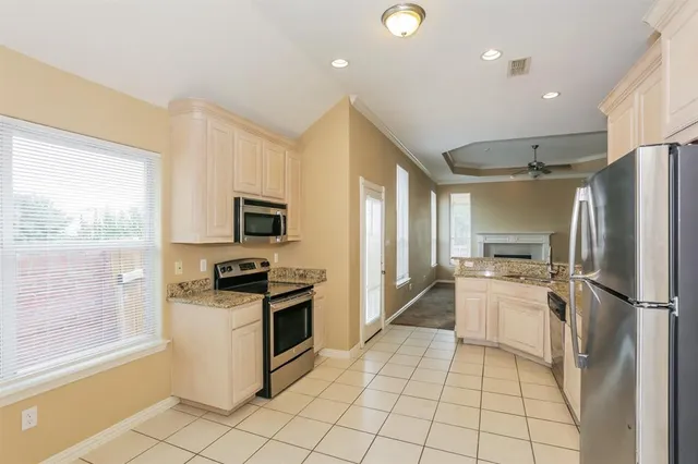 a kitchen with granite countertop a refrigerator and a stove top oven