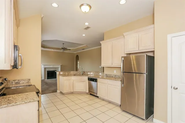 a kitchen with a sink a refrigerator and white cabinets