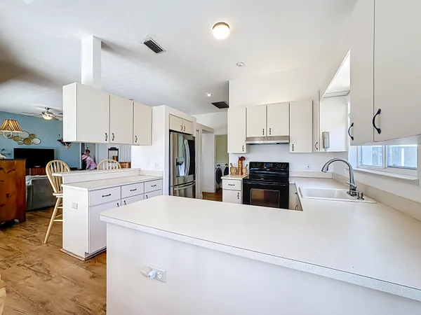 a kitchen with granite countertop a sink stainless steel appliances and white cabinets