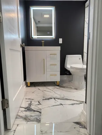 a bathroom with a toilet sink and mirror