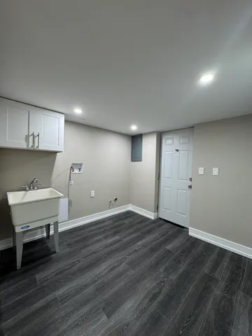a view of an empty room with wooden floor and a cabinet