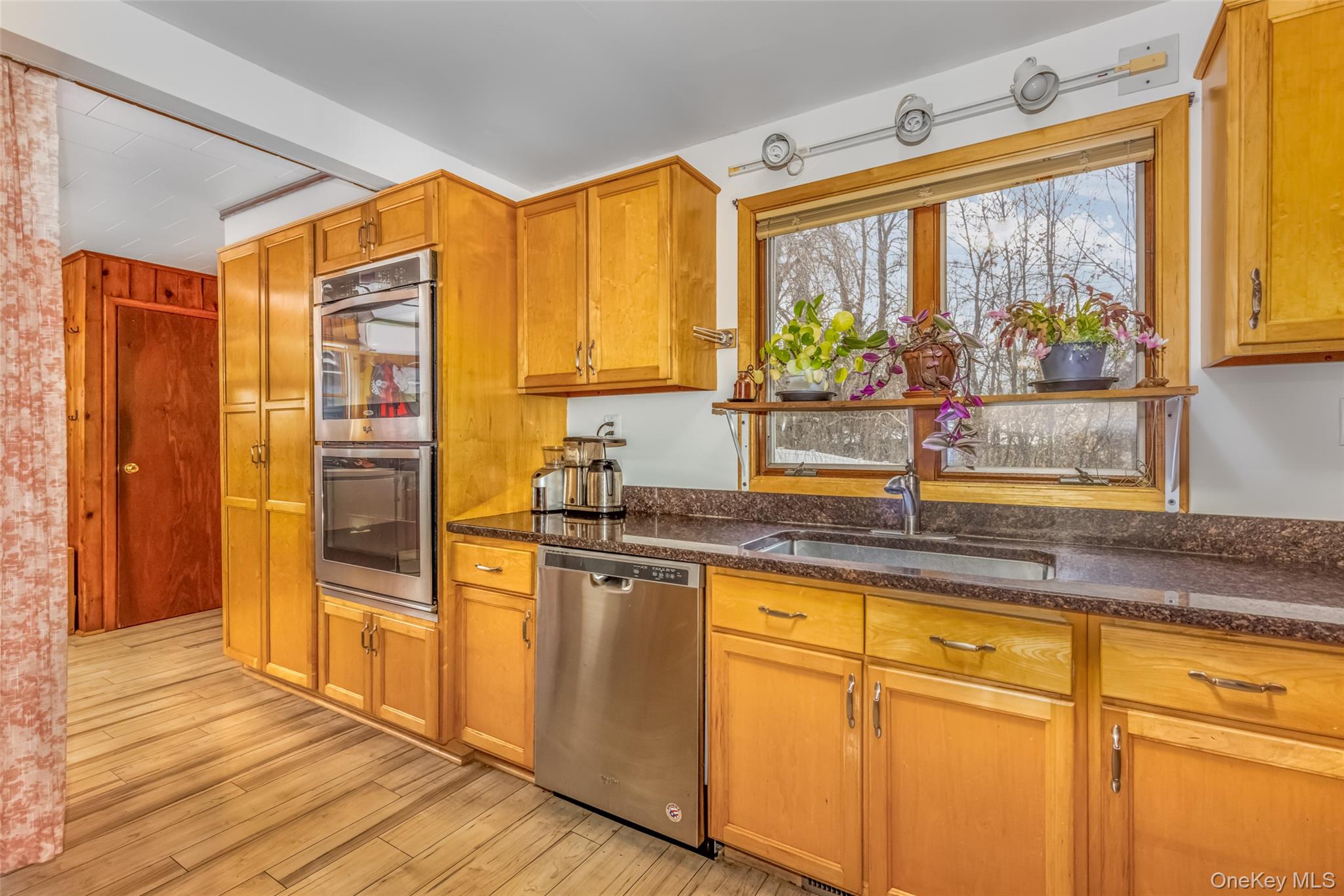 1896 Rte 44 55 Modena, NY 12548 - Photo 20 of 48 Kitchen featuring appliances with stainless steel finishes, dark stone countertops, brown cabinetry, and light wood-type flooring