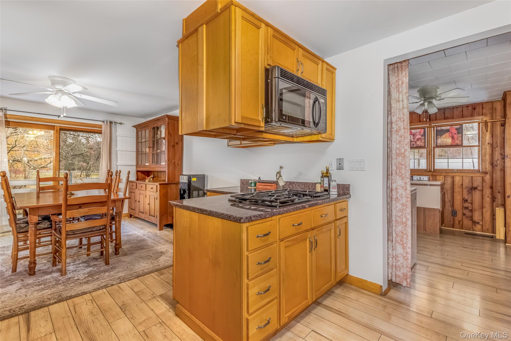 1896 Rte 44 55 Modena, NY 12548 - Photo 23 of 48 Kitchen featuring a ceiling fan, light wood-type flooring, black microwave, brown cabinets, and dark stone countertops