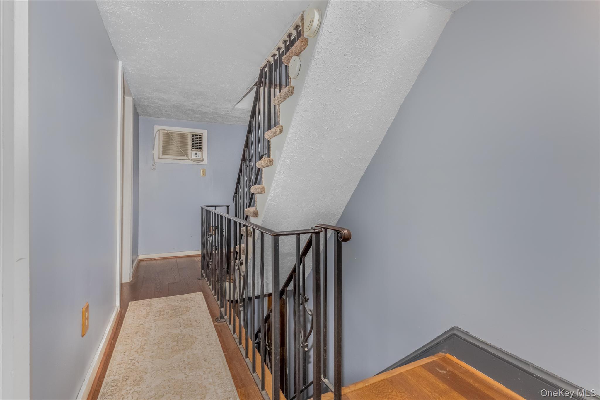 1896 Rte 44 55 Modena, NY 12548 - Photo 38 of 48 Staircase with wood finished floors, a textured ceiling, and a wall unit AC