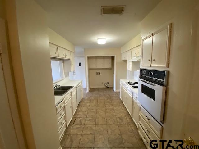 5700 Foxcroft Road Tyler, TX 75703 - Photo 2 of 10 a kitchen with white cabinets and appliances