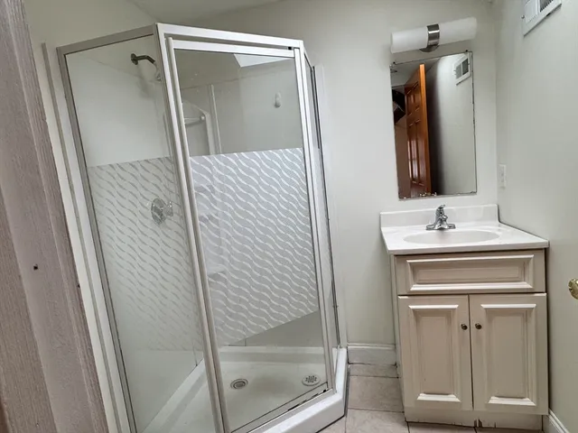 a bathroom with a shower sink and mirror