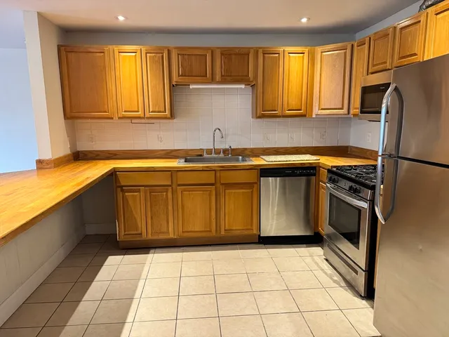 a kitchen with a sink a stove top oven and cabinets