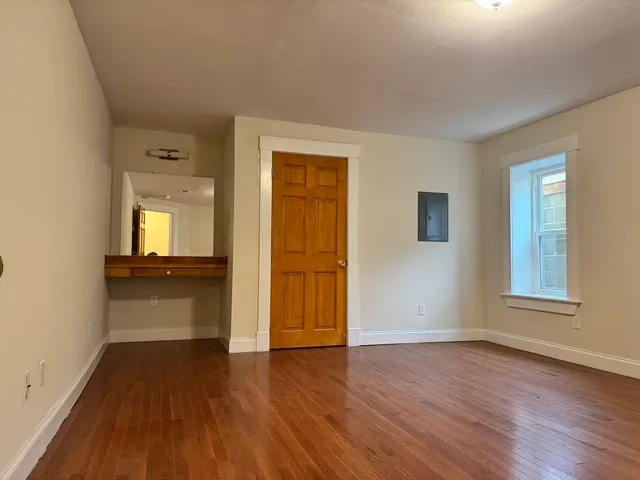 a view of a room with wooden floor and a window