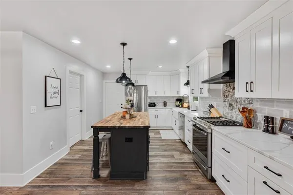 a kitchen with stainless steel appliances granite countertop a sink a stove and cabinets