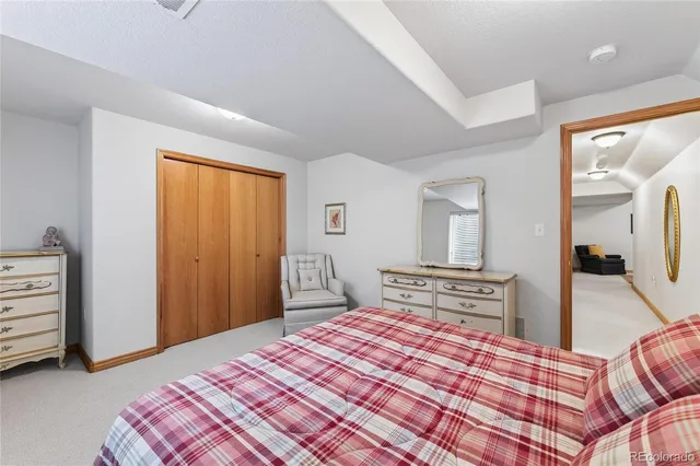 a bedroom with a bed and dresser with mirror