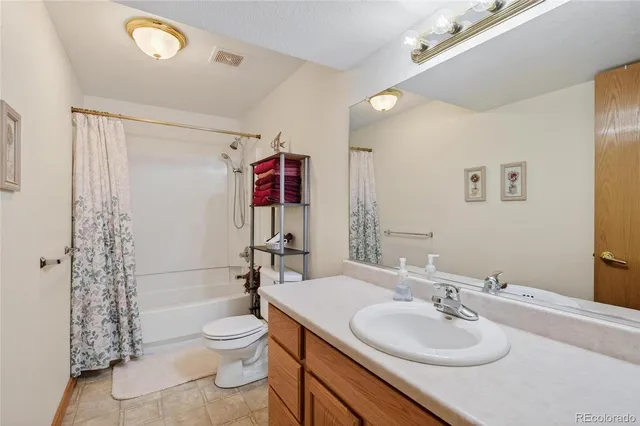 a bathroom with a granite countertop sink toilet a mirror and shower